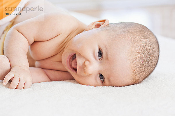 Gemischtrassiges Baby auf einer Decke liegend