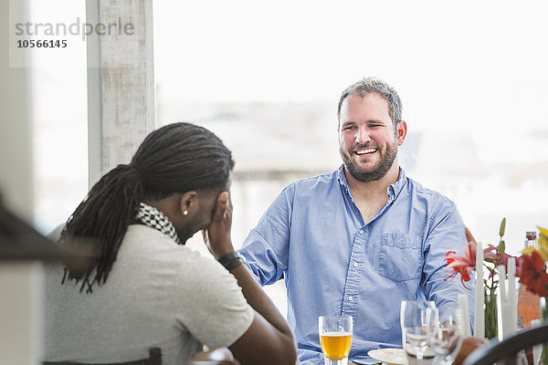 Lachende Männer am Esstisch