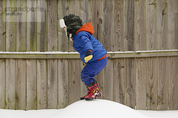 Kaukasischer Junge spielt im Schnee