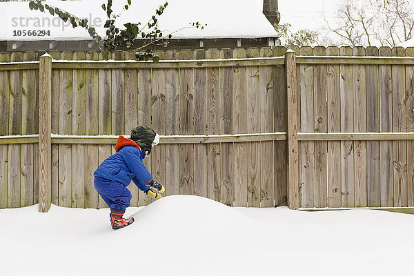 Kaukasischer Junge spielt im Schnee