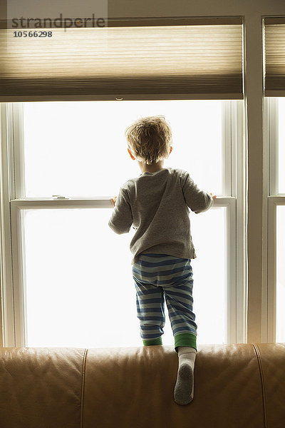 Kaukasischer Junge schaut aus dem Fenster