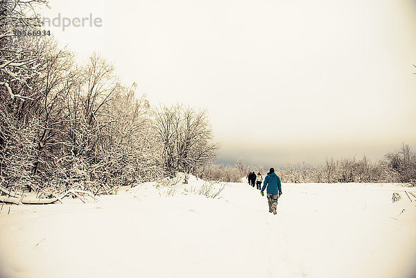 Kaukasische Wanderer  die im Schnee wandern