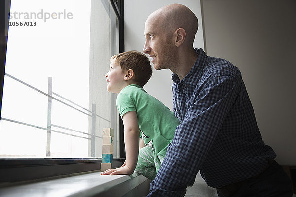 Vater und Sohn schauen aus dem Fenster
