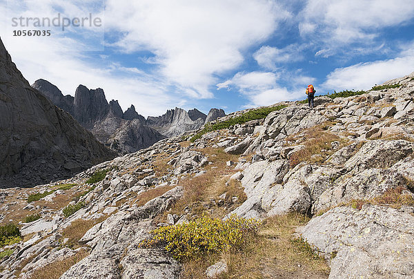 Kaukasischer Wanderer  der auf einem felsigen Berghang spazieren geht