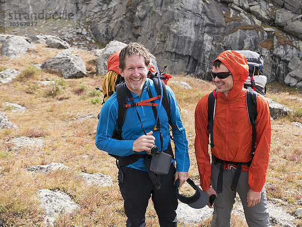 Lächelnde kaukasische Wanderer am Hang