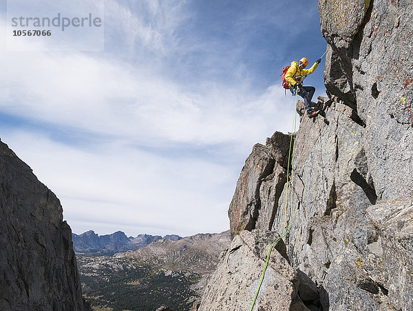 Kaukasischer Bergsteiger beim Abseilen am Berghang