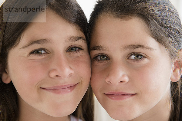 Kaukasische Zwillingsschwestern lächelnd