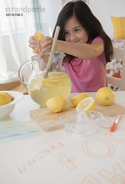 Mädchen presst Zitronen zu Limonade aus