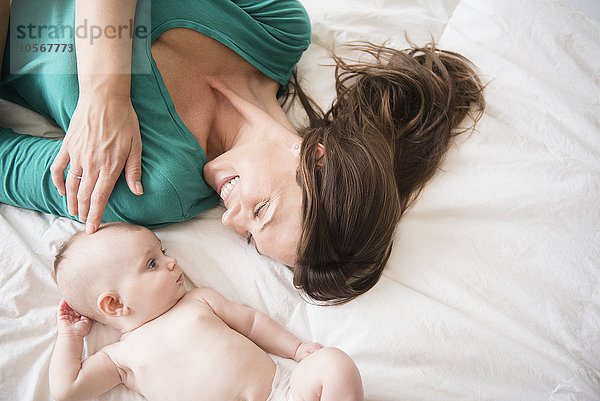 Mutter liegt mit ihrer kleinen Tochter