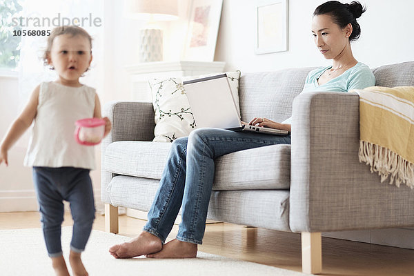 Mutter benutzt Laptop und ignoriert ihre kleine Tochter