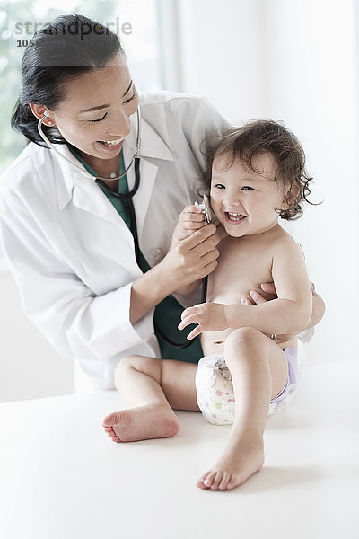 Arzt und kleines Mädchen spielen mit Stethoskop