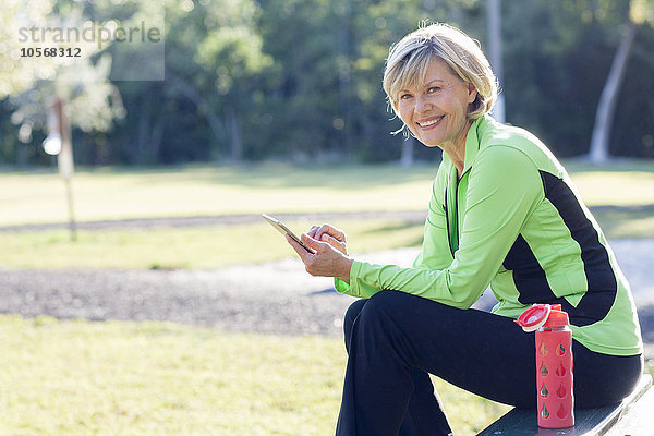 Kaukasische Frau benutzt digitales Tablet im Park