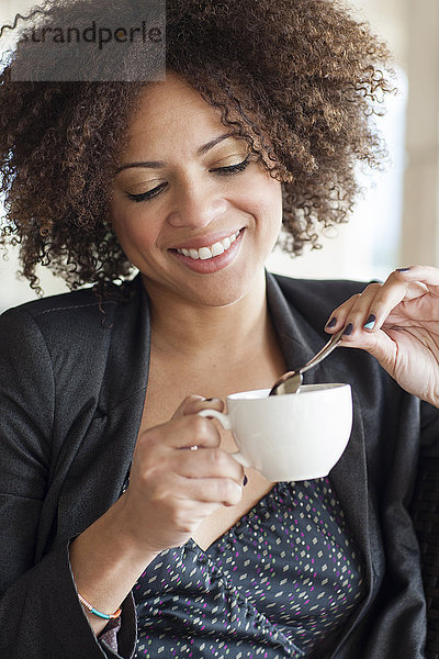 Gemischtrassige Geschäftsfrau trinkt eine Tasse Kaffee