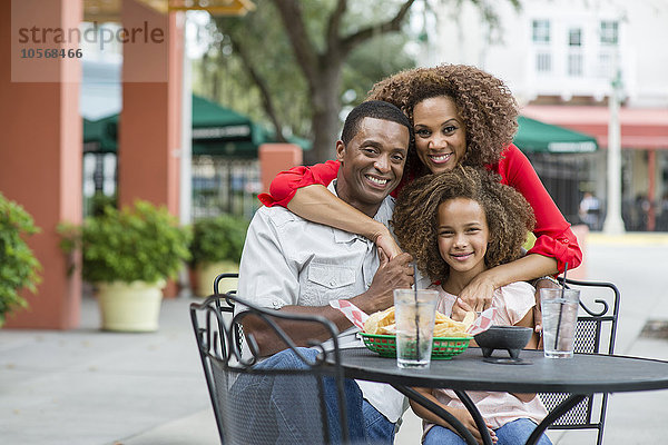 Lächelnde Familie am Tisch eines Restaurants im Freien