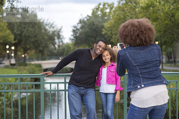 Mutter fotografiert Familie auf Brücke