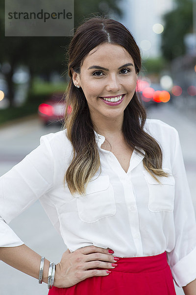 Hispanische Geschäftsfrau lächelnd im Freien
