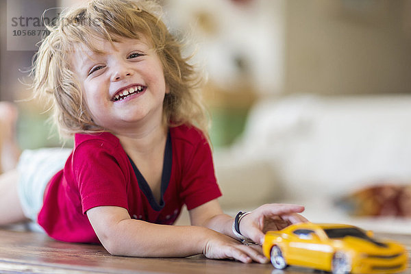 Kaukasischer Junge spielt mit Spielzeugauto