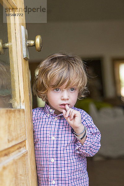 Kaukasischer Junge schaut aus der offenen Tür
