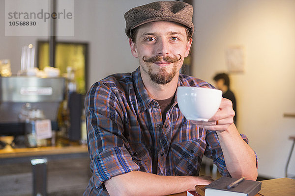 Kaukasischer Mann trinkt Kaffee in einem Cafe