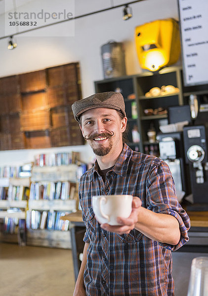 Kaukasischer Barista serviert Kaffee im Café