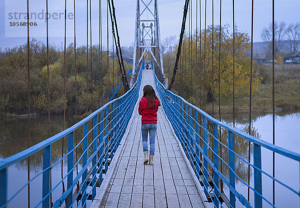 Kaukasisches Mädchen geht auf Brücke