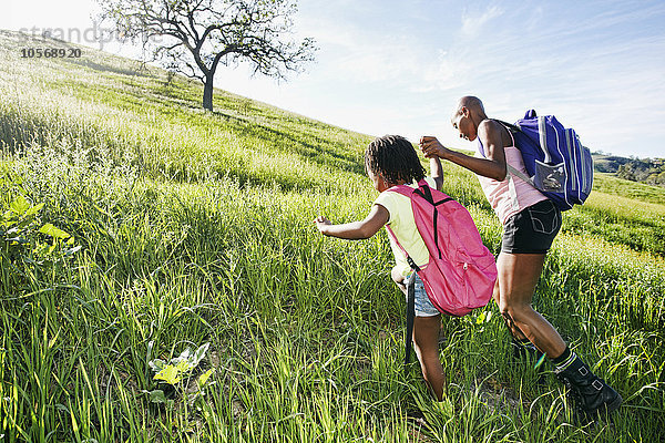 Schwarze Mutter und Tochter gehen auf einem ländlichen Hügel spazieren