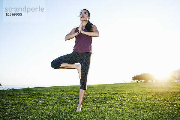 Asiatische Frau übt Yoga im Freien