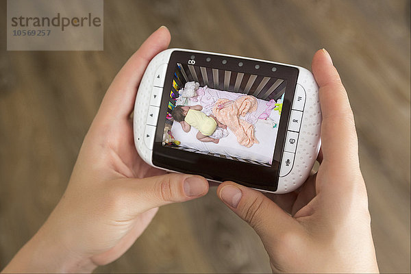 Gemischtrassige Mutter beobachtet Babyphone