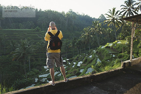 Kaukasischer Tourist beim Fotografieren einer ländlichen Reisterrasse  Ubud  Bali  Indonesien