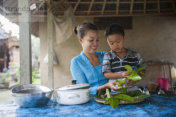 Asiatische Mutter und Sohn kochen in der Außenküche