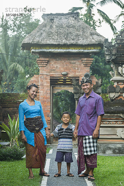 Asiatische Mutter  Vater und Sohn lächelnd vor dem Torbogen