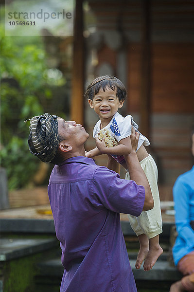 Asiatischer Vater spielt mit seinem Sohn im Freien