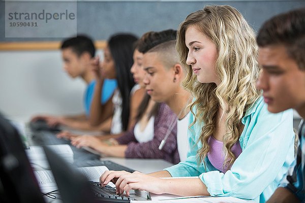 Reihe von jugendlichen High-School-Schülern beim Tippen am Computer