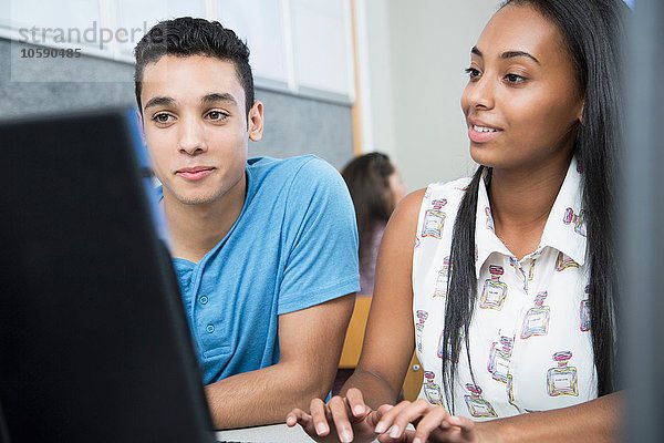 Zwei Jugendliche  die in der High-School-Klasse am Computer arbeiten.