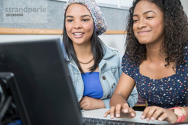 Zwei Teenager-Mädchen tippen in der High-School-Computerklasse