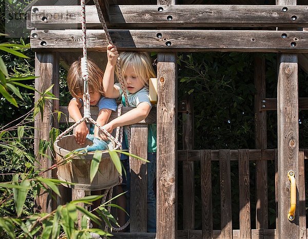 Zwei kleine Jungen spielen im Baumhaus