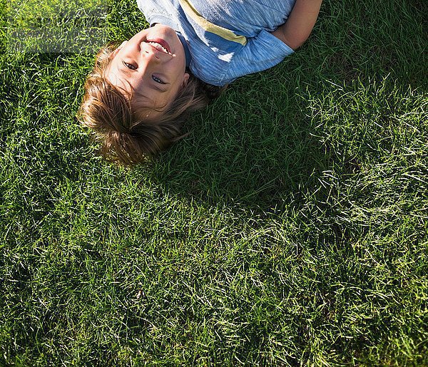 Junge auf Gras liegend  Draufsicht