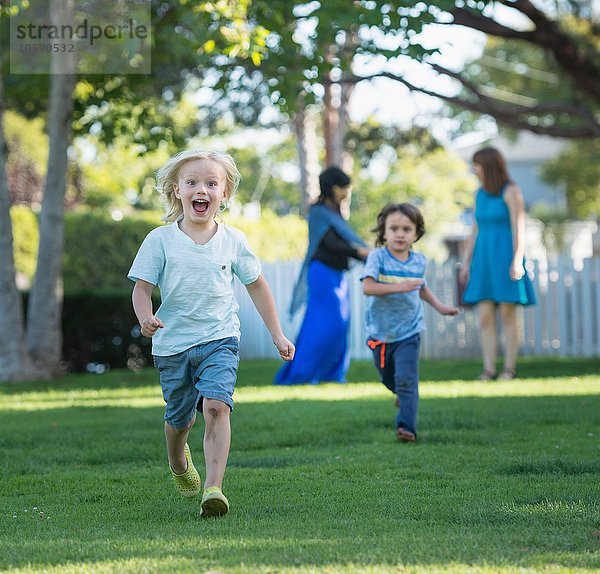 Zwei kleine Jungen beim Rennen im Garten