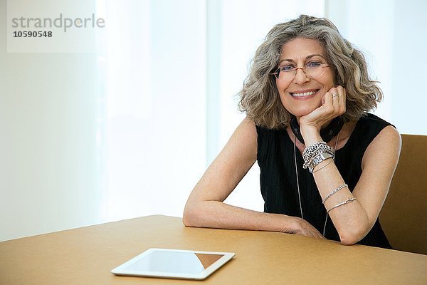 Portrait einer Senior-Designerin mit digitalem Tablett am Konferenztisch