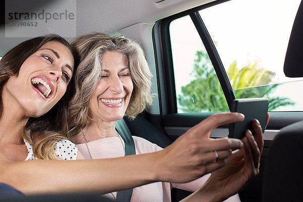 Senior Frau und Tochter unter Smartphone Selfie im Auto