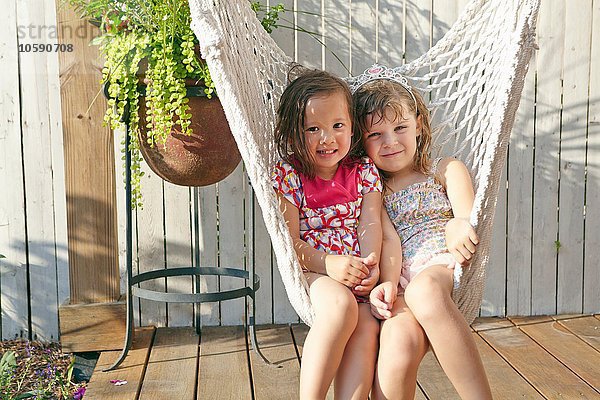 Mädchen sitzen in der Hängematte auf der Veranda