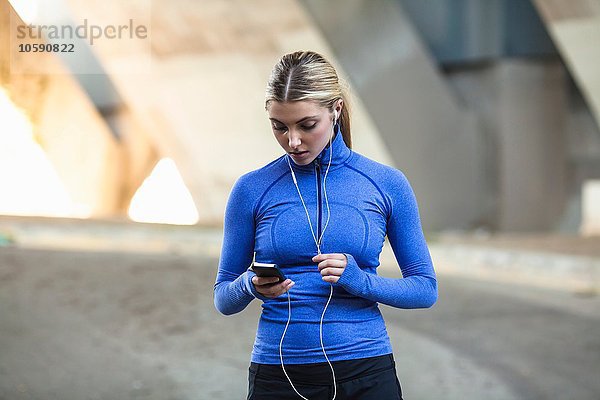Jogger beim Auswählen von Musik auf dem Smartphone