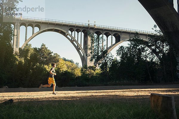 Joggerlauf  Bogenbrücke im Hintergrund  Arroyo Seco Park  Pasadena  Kalifornien  USA