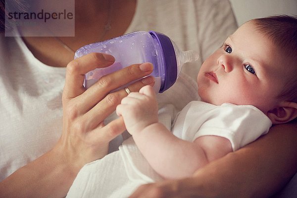 Mutter füttert Baby in den Armen