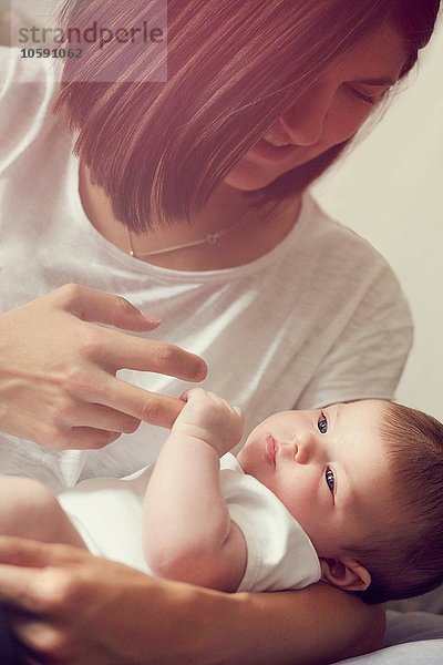 Mutter mit den Fingern des Babys