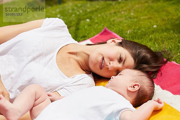 Mutter spielt mit Baby auf Rasen