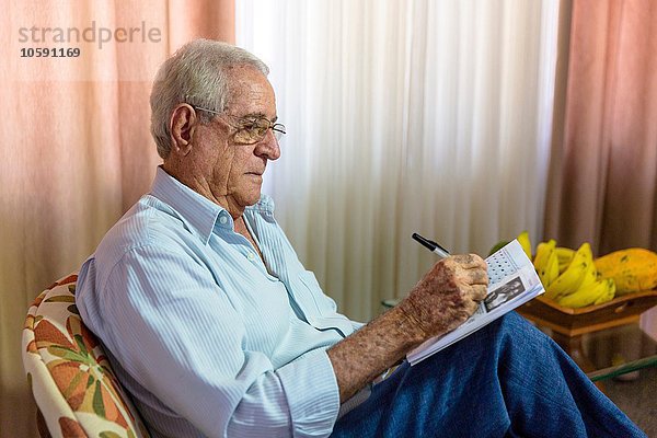 Älterer Mann beim Schreiben in einem Notizbuch