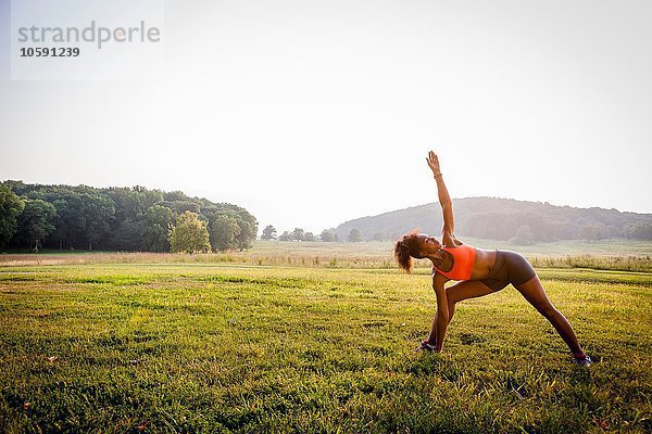 Junge Frau beim Yoga im ländlichen Park