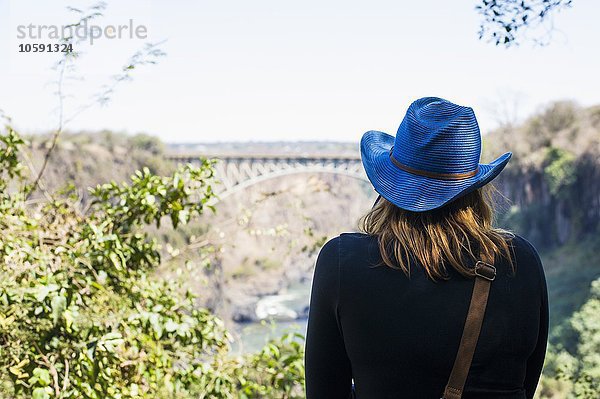 Rückansicht der jungen Frau mit Blick auf die Brücke  Victoria Falls  Sambia