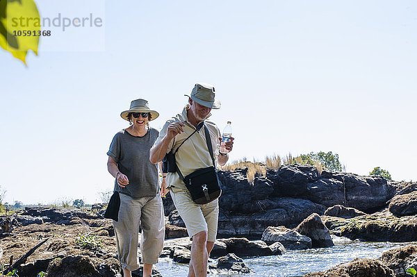 Senior Mann und Frau erkunden Flussfelsen  in der Nähe von Victoria Falls  Sambia